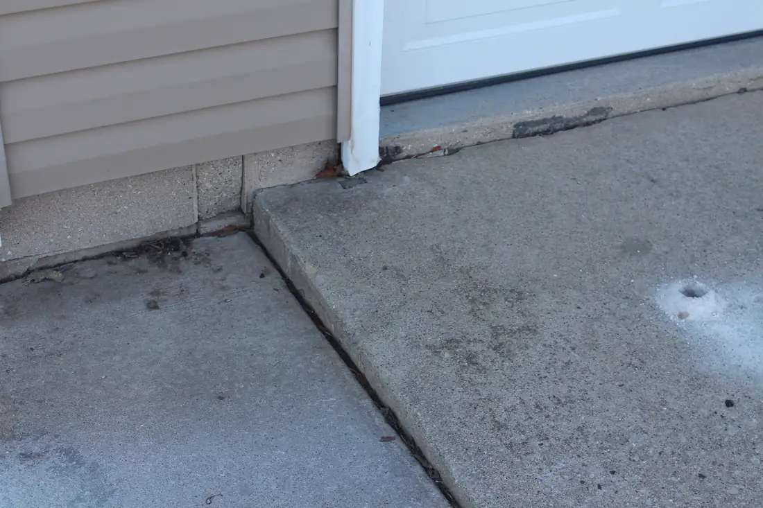 Before sidewalk leveling in Berrien County, MI showing an uneven sidewalk panel and trip hazard before concrete lifting