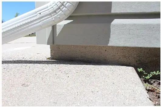 Concrete settling near a downspout before repair in Berrien County MI